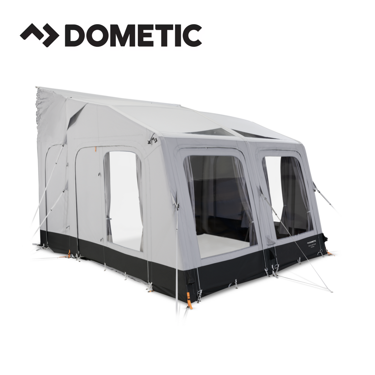 Dometic Rally Air Tour driveaway awning set up beside a camper van in a scenic outdoor setting.