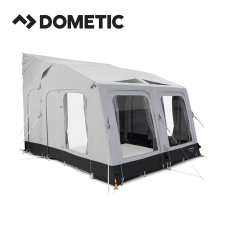 Dometic Rally Air Tour driveaway awning set up beside a camper van in a scenic outdoor setting.