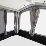 Dometic Club Air Tour 260 driveaway awning set up beside a van, showcasing its spacious design and durable fabric.