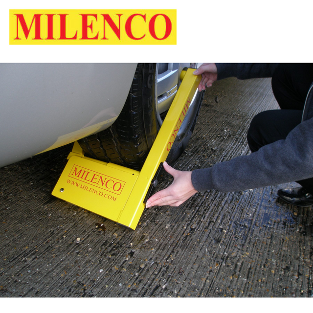 Milenco Compact Wheel Clamp 2745 securely fits over a wheel, featuring a bright yellow design for visibility and security.
