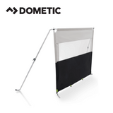 Dometic Pro poled windbreak set up outdoors, showcasing sturdy poles and fabric barrier for wind protection.