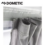 Dometic Rally Air Stay 260s awning attached to a camper, showcasing its fabric, support arms, and attachment points.