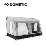 Dometic Rally Tour poled awning set up beside a caravan, showcasing its spacious design and sturdy poles in a sunny outdoor setting.